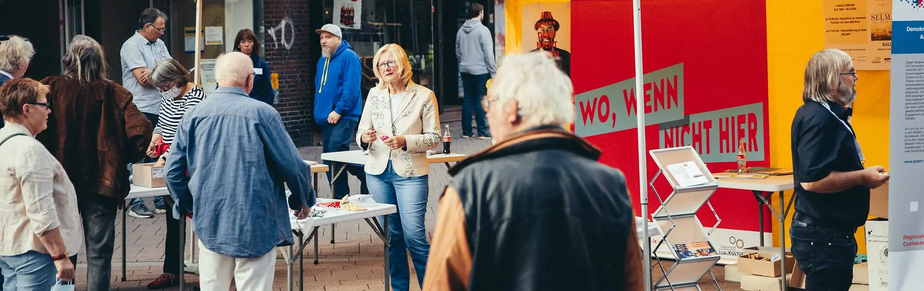 Infostand in Fußgängerzone mit Betreuenden und Besuchenden