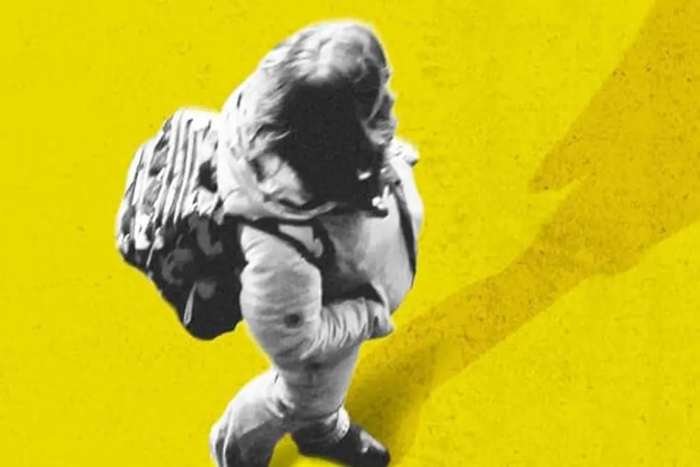 Ein Mädchen mit Rucksack steht auf einem großen gelben Kreis