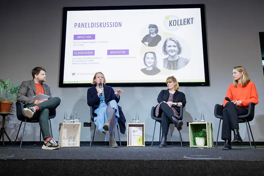 Vier Personen sitzen auf einer Bühne