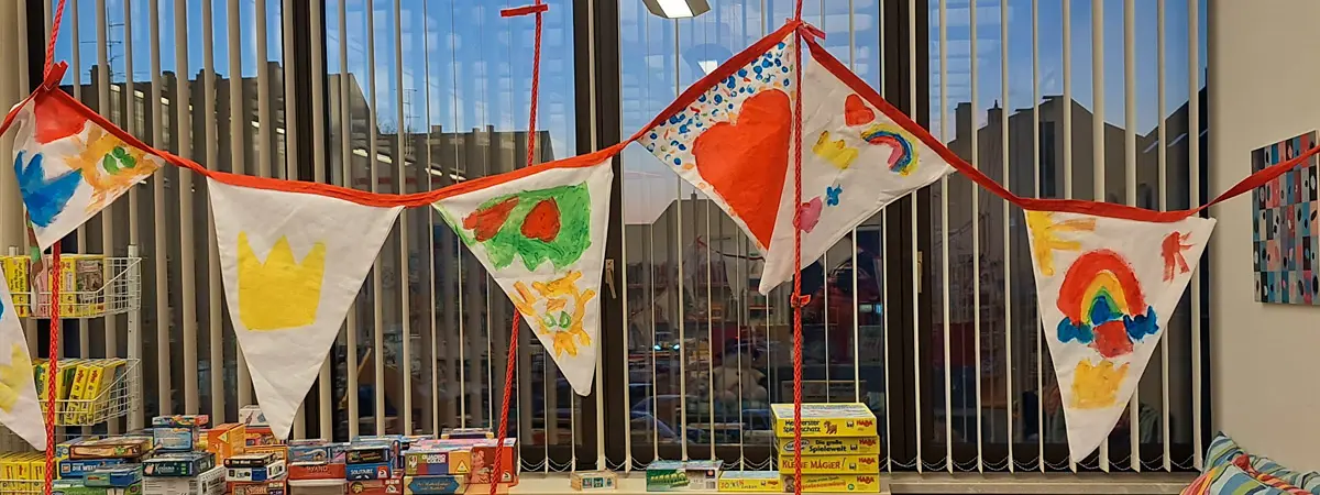 Wimpelgirlande unter anderem mit Herzen, Kronen und Regenbogen