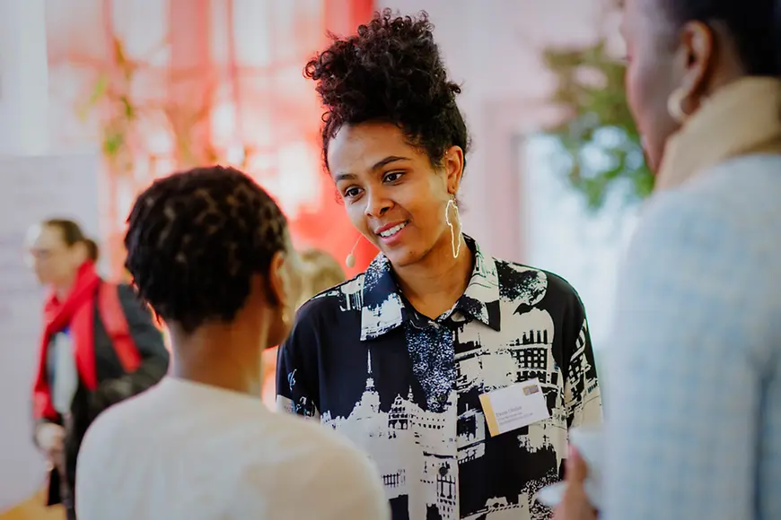 Eine Schwarze Frau spricht mit einer zweiten Schwarzen Frau.