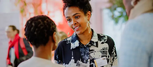 Eine Schwarze Frau spricht mit einer zweiten Schwarzen Frau.