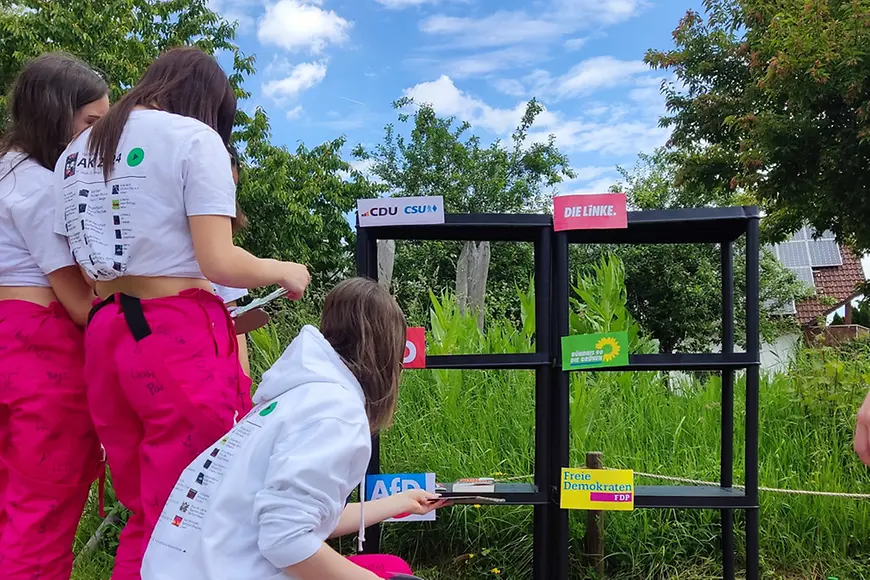 Drei junge Frauen stehen vor einem Regal und nehem eine Zuordnung vor.