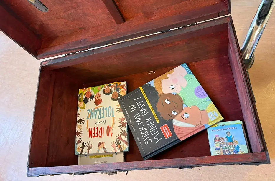 In einer geöffneten Schatztruhe liegen Bücher.