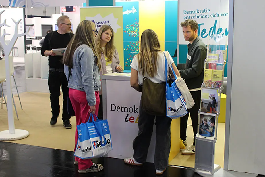 Mehrere Personen informieren sich am Messestand von "Demokratie leben!"