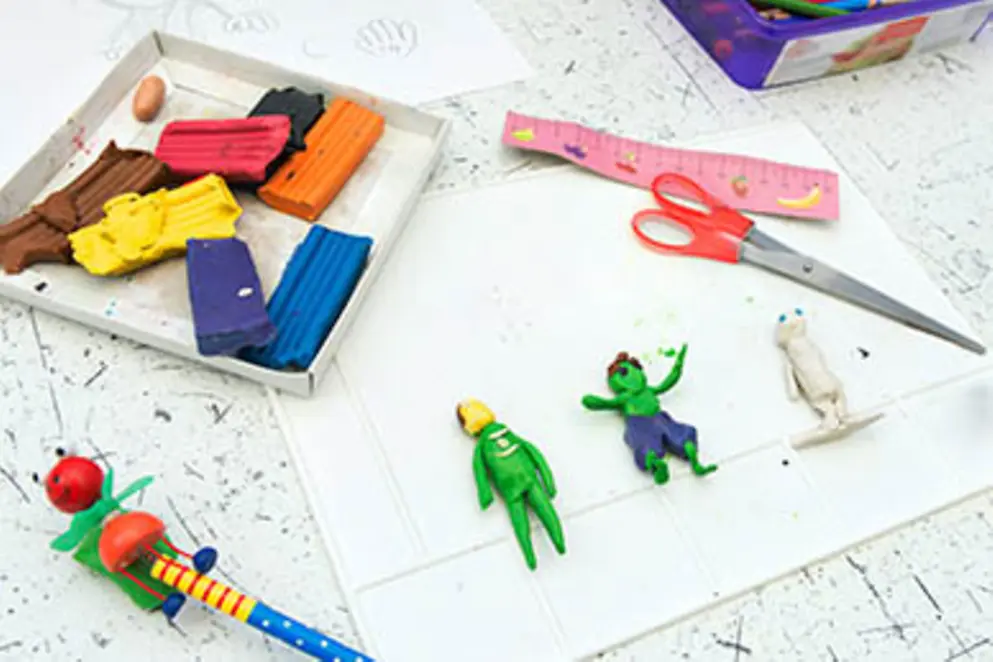 Basteltisch mit Knete, Schere, Linial und Knetfiguren